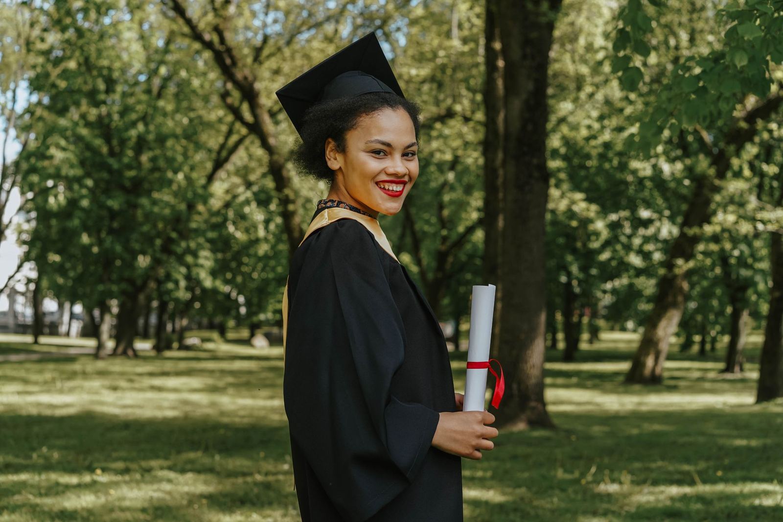 A smiling graduate holding her diploma