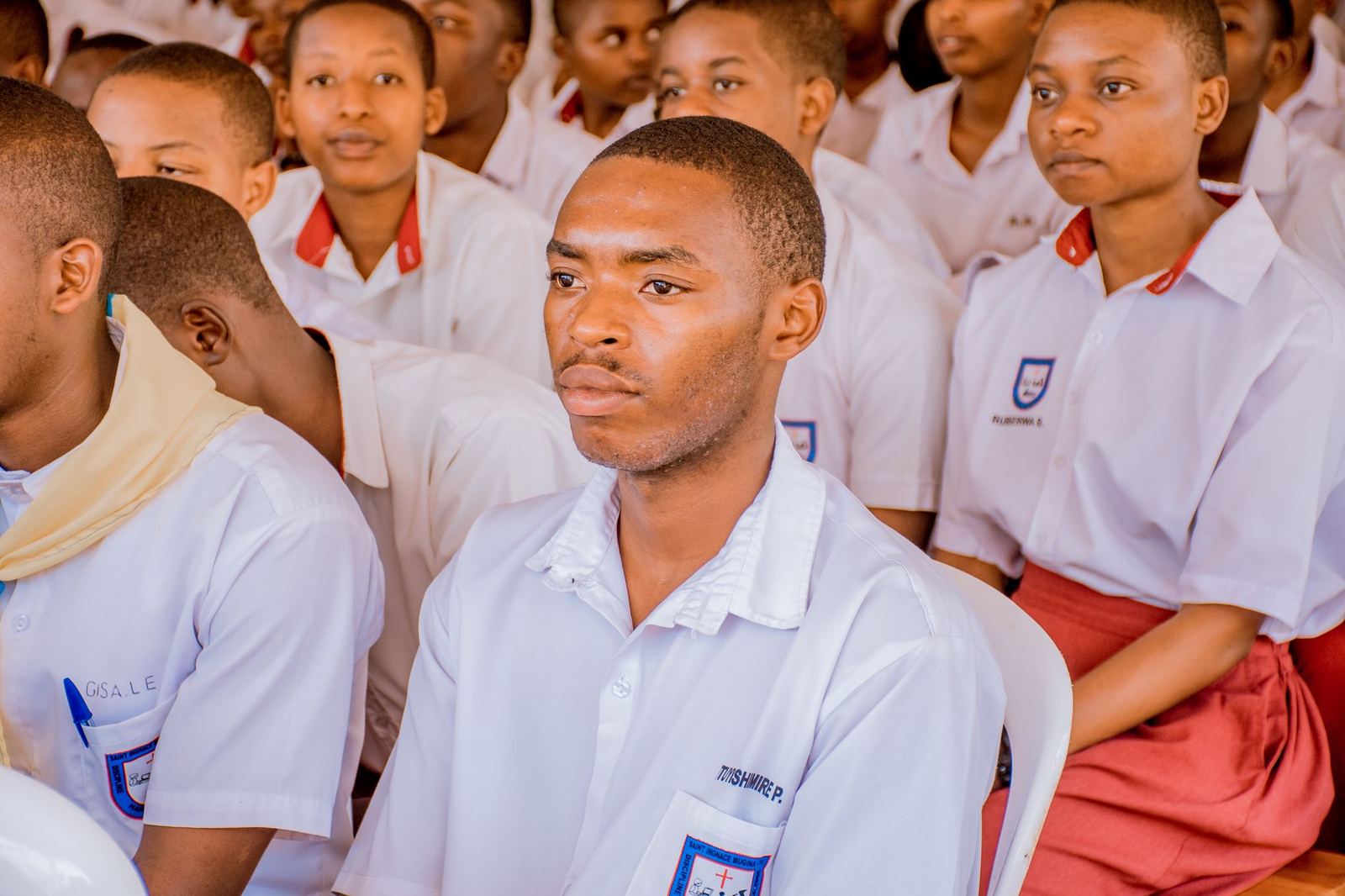 Students in a school hall listening to a lesson